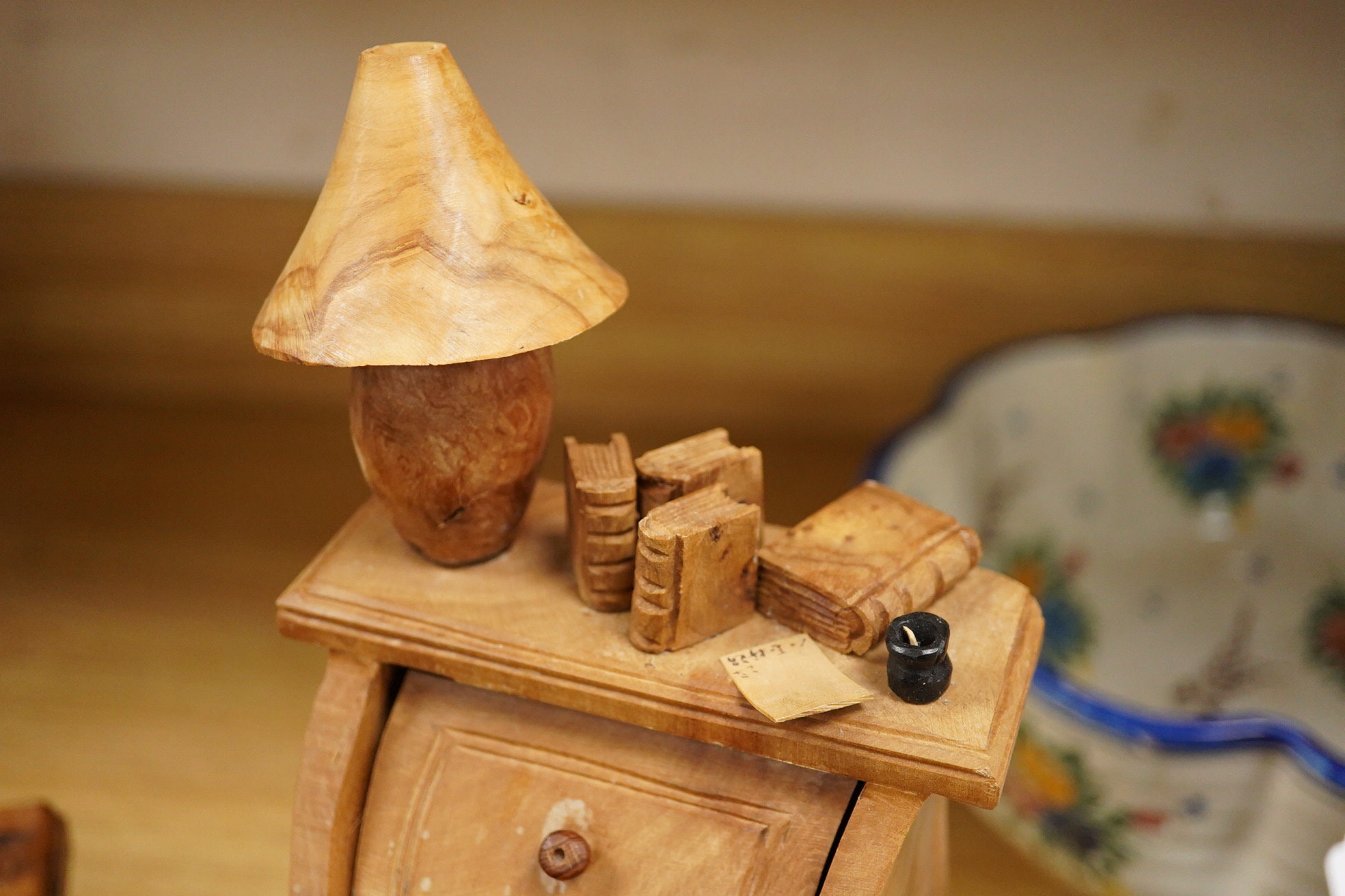 Two Piere Decorse (b.1953), a naturalistically modelled sculpture of a miniature carved novelty bureau and a sideboard, both surmounted with books and a lamp, largest 39cm high